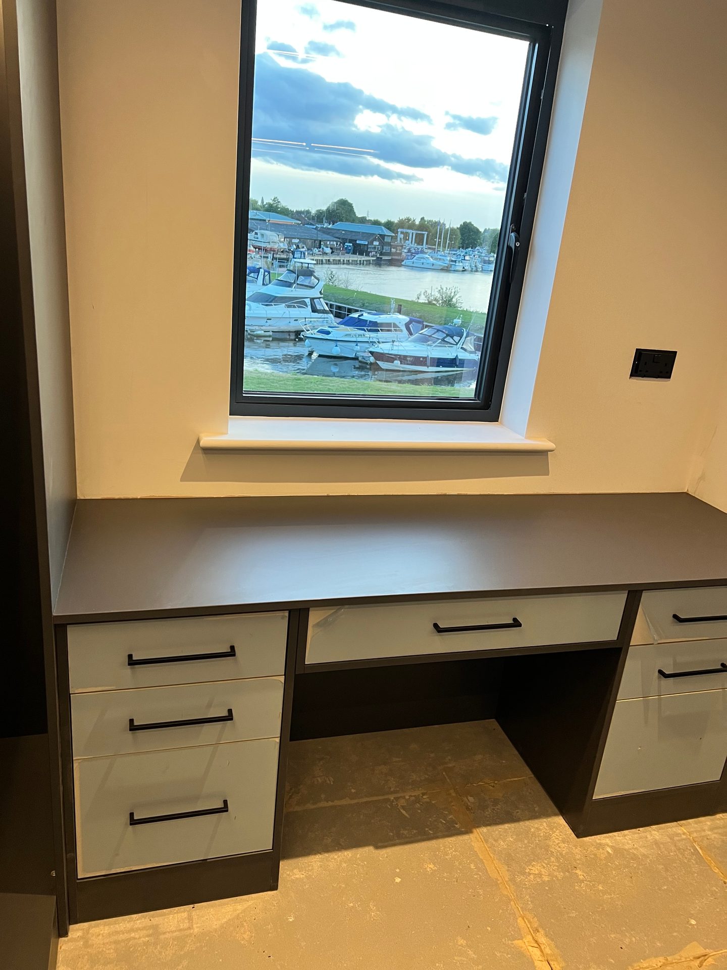 Built-in desk with drawer pedestals each side under a window