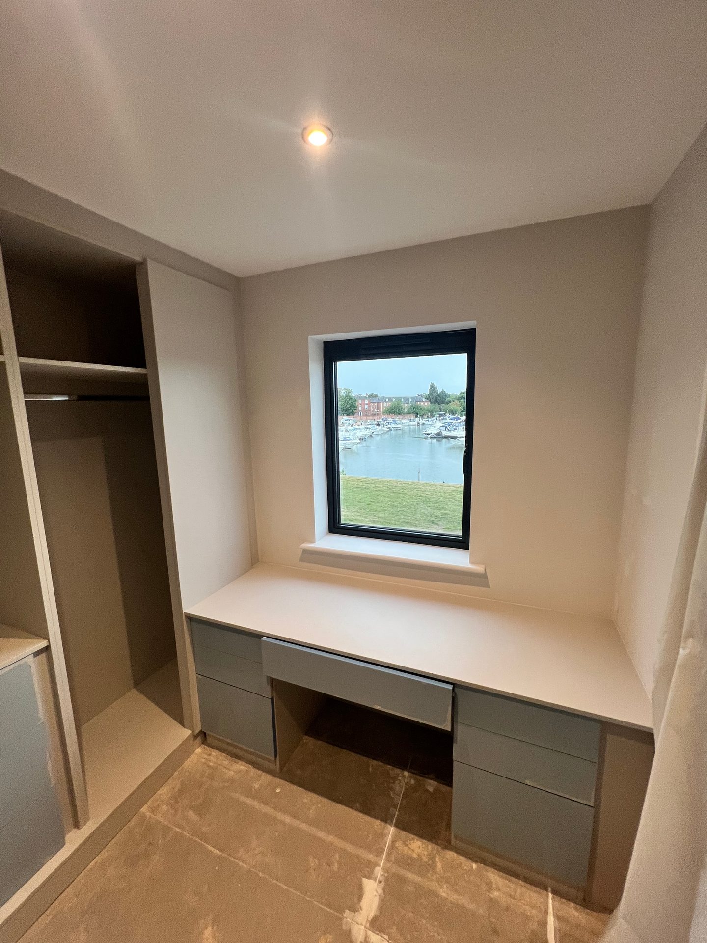 Desk built into an alcove between wardrobes