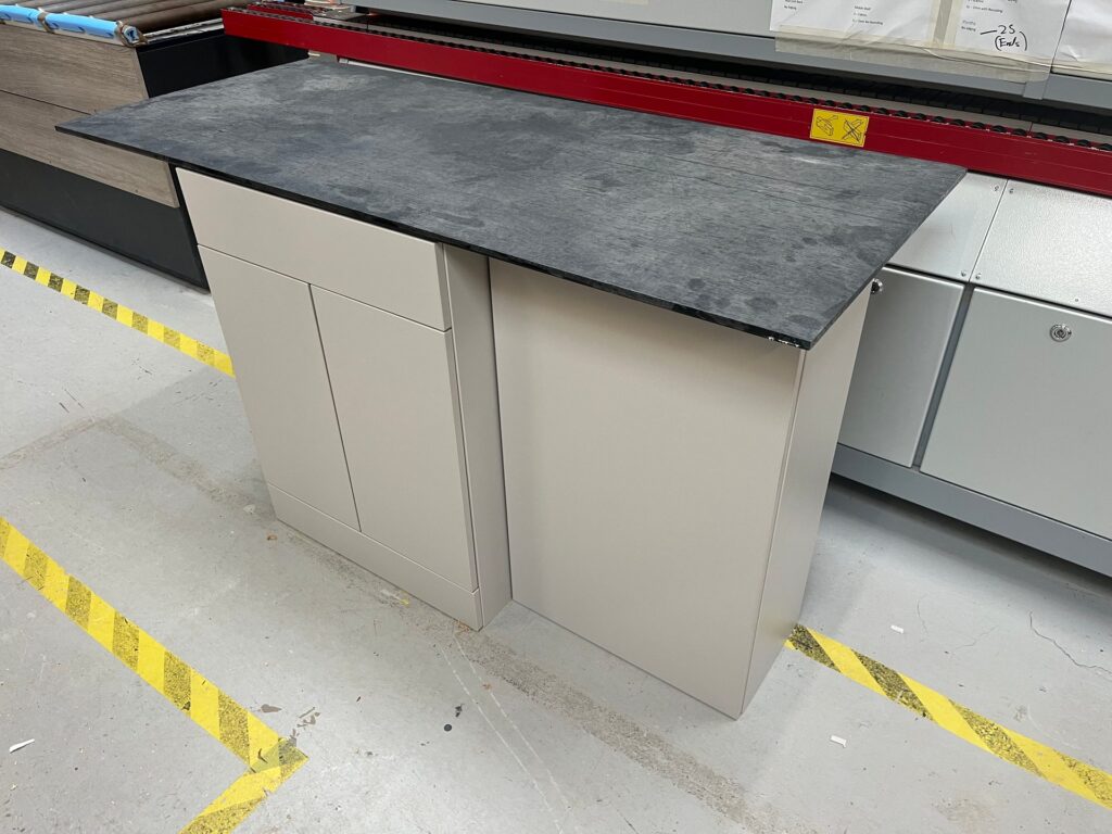 Peninsula unit with a dark stone-effect worktop in the DTJ Interiors workshop