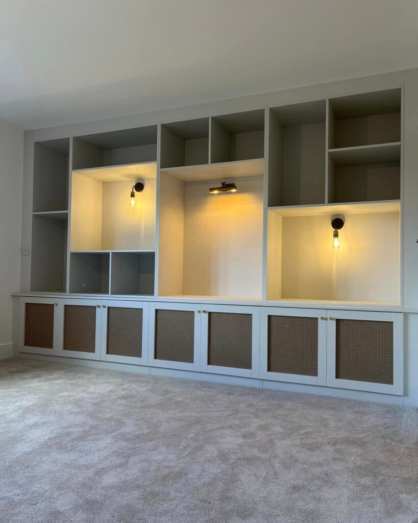 Media wall shelving with lit niches and woven-panel cupboard doors