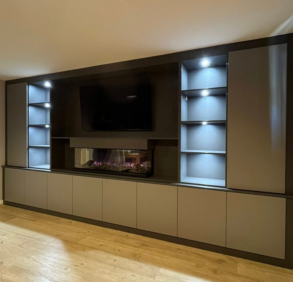 Grey media wall with an inset fire, TV recess and lit open shelves