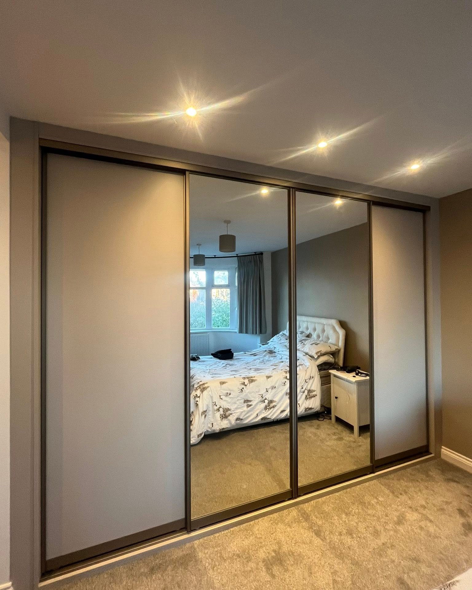 Fitted sliding wardrobe with two mirrored doors and two plain panels