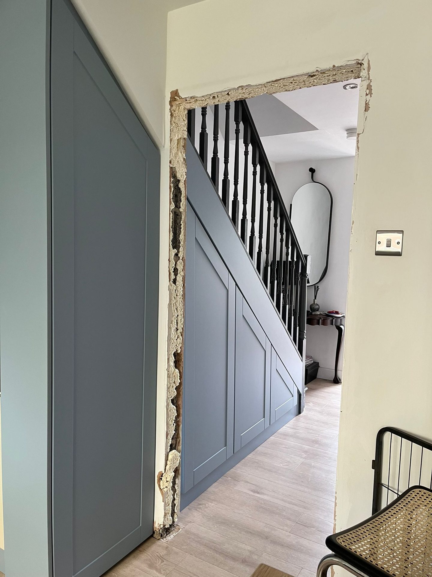 Blue-grey shaker cupboards fitted under a staircase