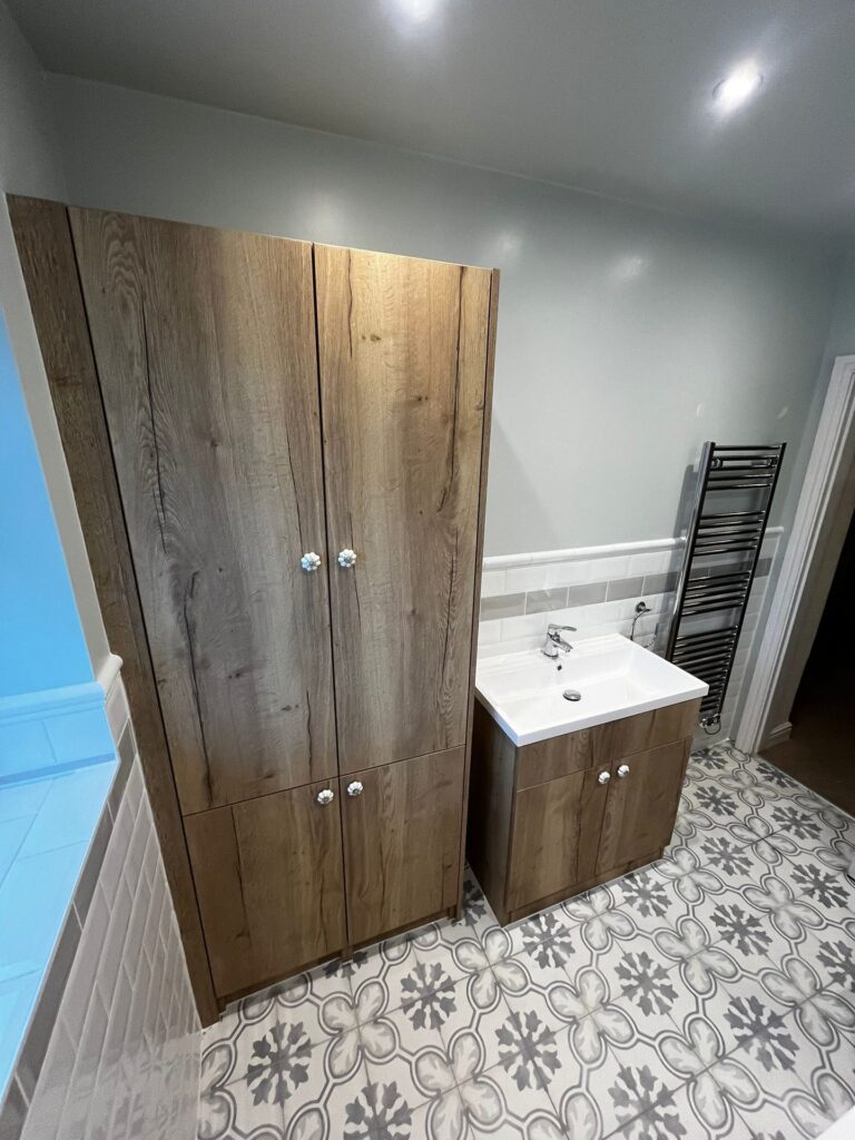 A tall bathroom cupboard and vanity unit