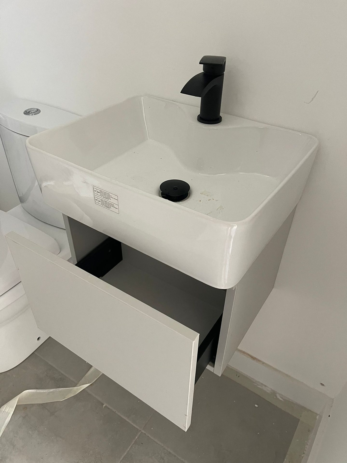 White wall-hung vanity unit with a pull-out drawer